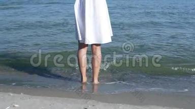 光着脚站在沙滩上的女人。 女孩站在浅水里享受大自然。 海滨，海洋。 健康
